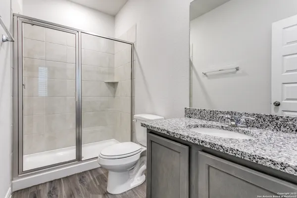 a bathroom with a granite countertop sink toilet and shower