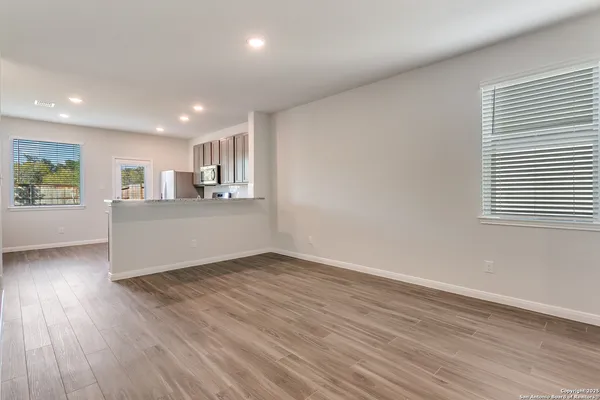 a view of a kitchen with wooden floor and a window