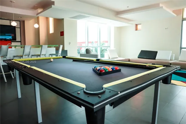 a view of a pool table and chairs in a room