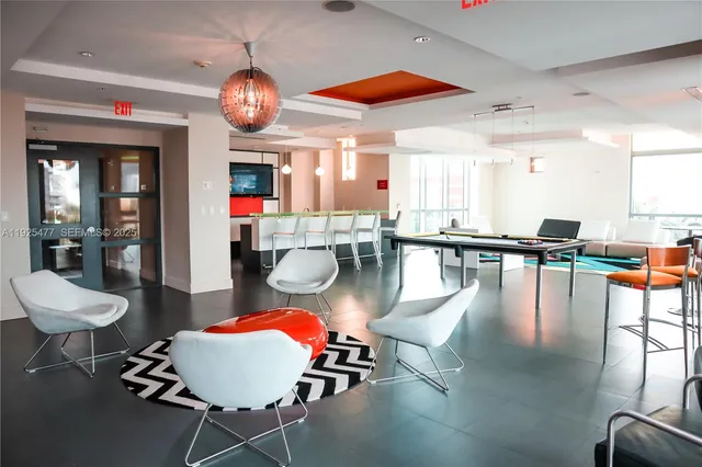 a room with wooden floor pool table and chairs