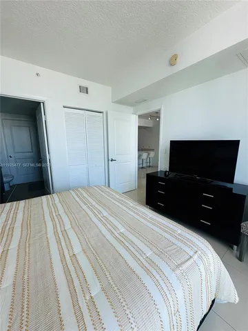 a bed room with a bed and a television