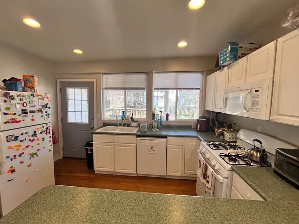 a kitchen with granite countertop a sink stove and refrigerator