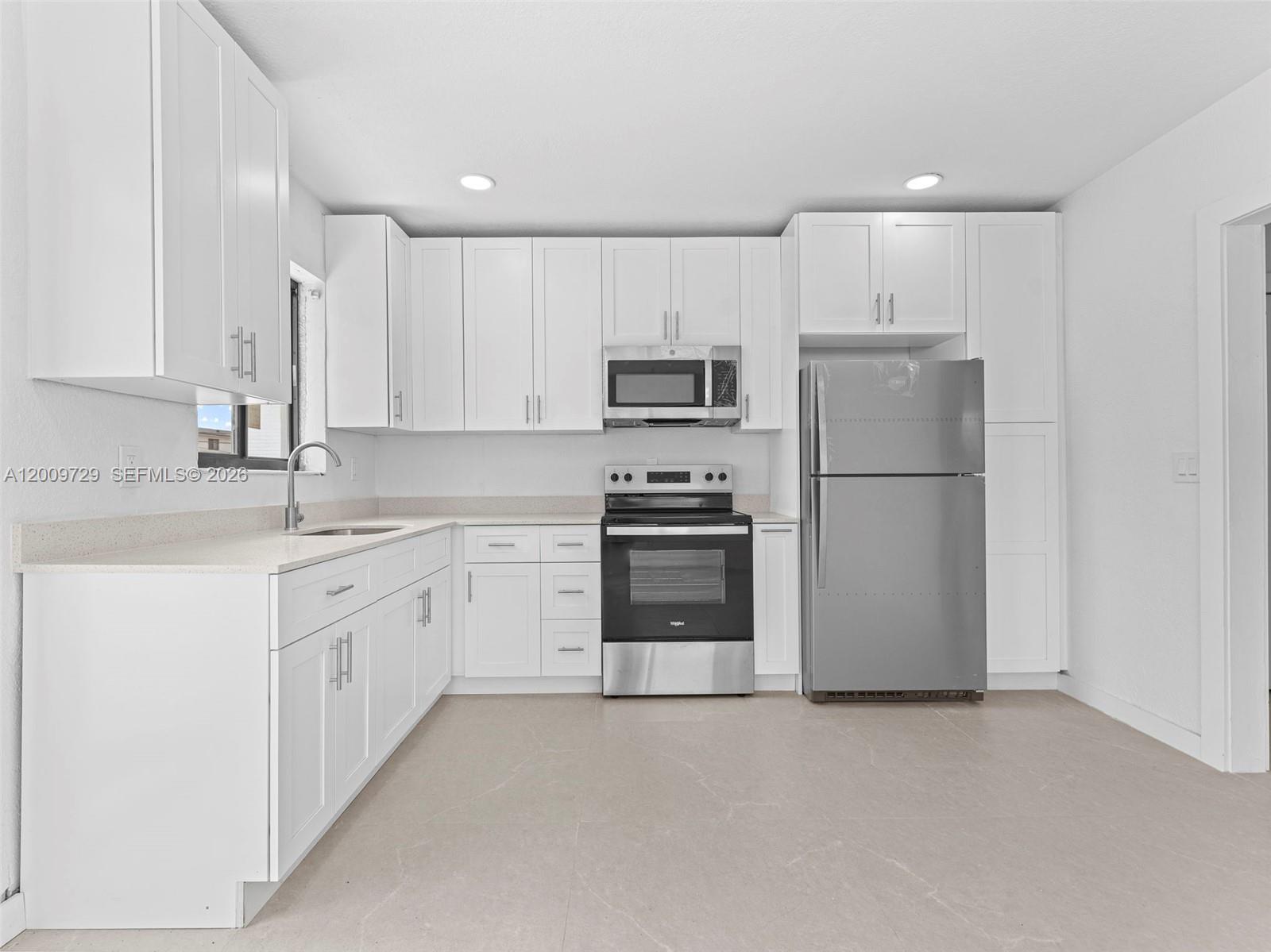 1370 West 29th Street, Unit B Hialeah, FL 33012 - Photo 15 of 15 a kitchen with granite countertop white cabinets and stainless steel appliances