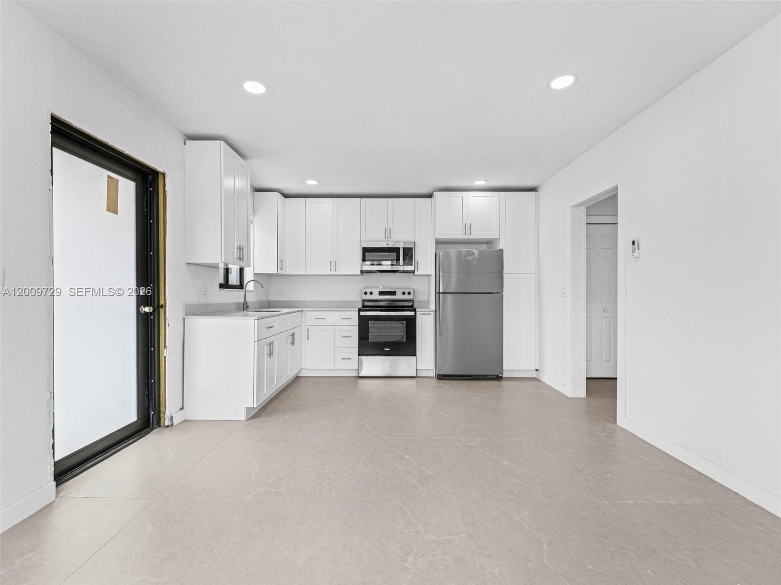 1370 West 29th Street, Unit B Hialeah, FL 33012 - Photo 9 of 15 a kitchen with stainless steel appliances a refrigerator sink and microwave