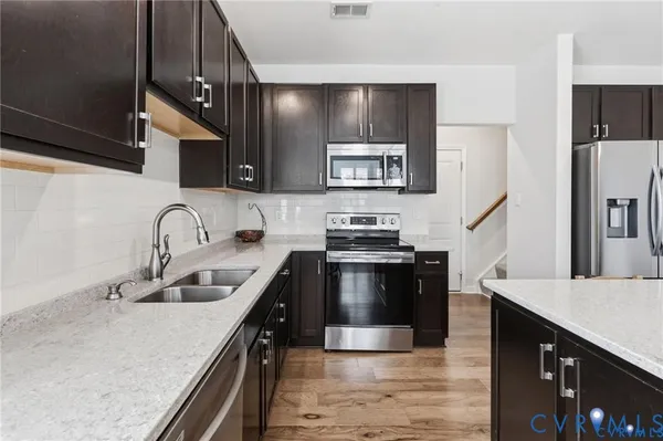 a kitchen with stainless steel appliances granite countertop a sink stove and refrigerator