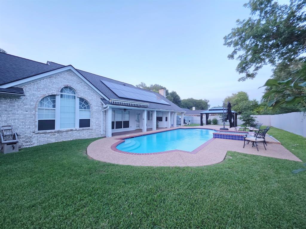 520 Red River Road Belton, TX 76513 - Photo 32 of 36 Backyard featuring a blue-tiled swimming pool with integrated steps, surrounded by an exposed aggregate deck