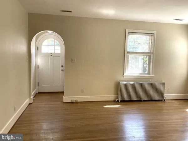 an empty room with wooden floor and window