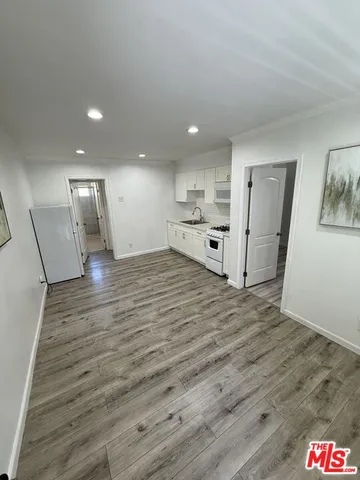a view of a refrigerator in kitchen and wooden floor