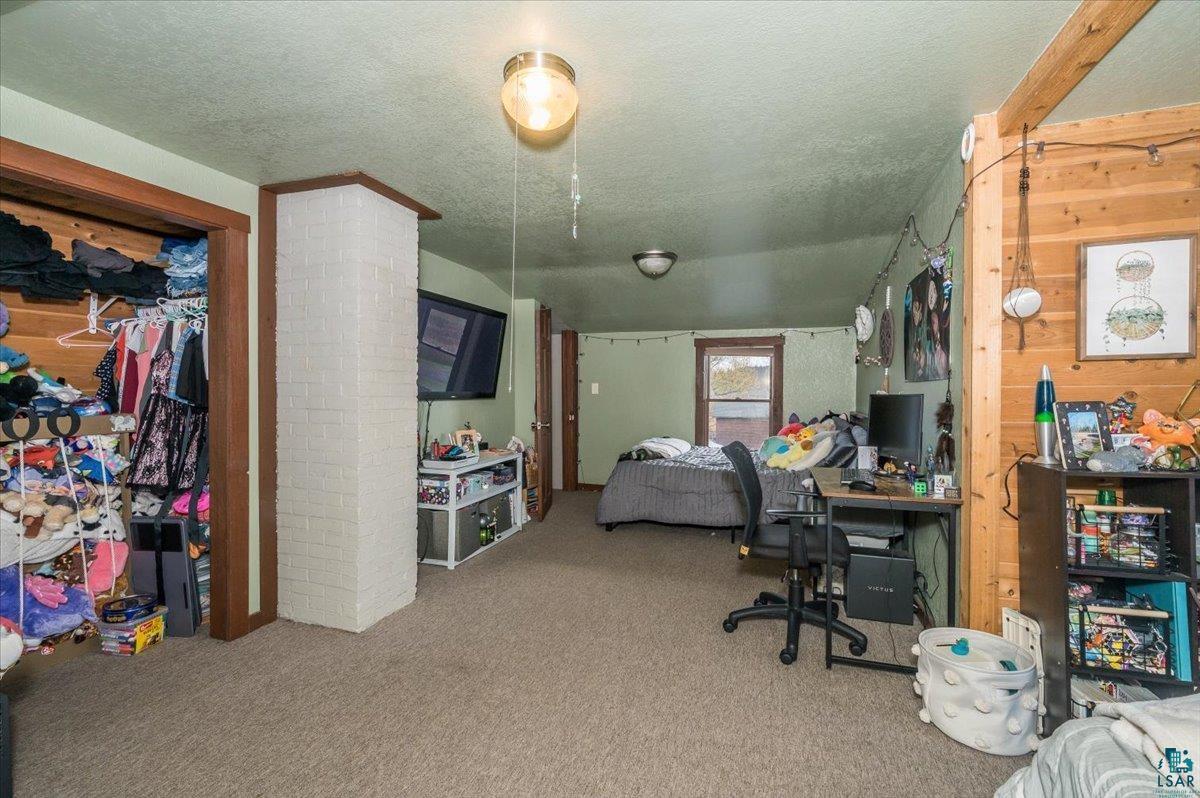 7702 East Rockmont Road Poplar, WI 54864 - Photo 14 of 22 Bedroom with a textured ceiling and carpet