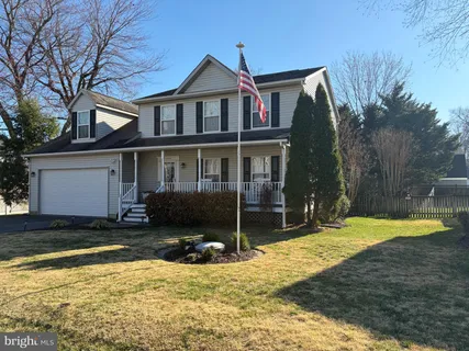 a view of a house with a yard and large tree