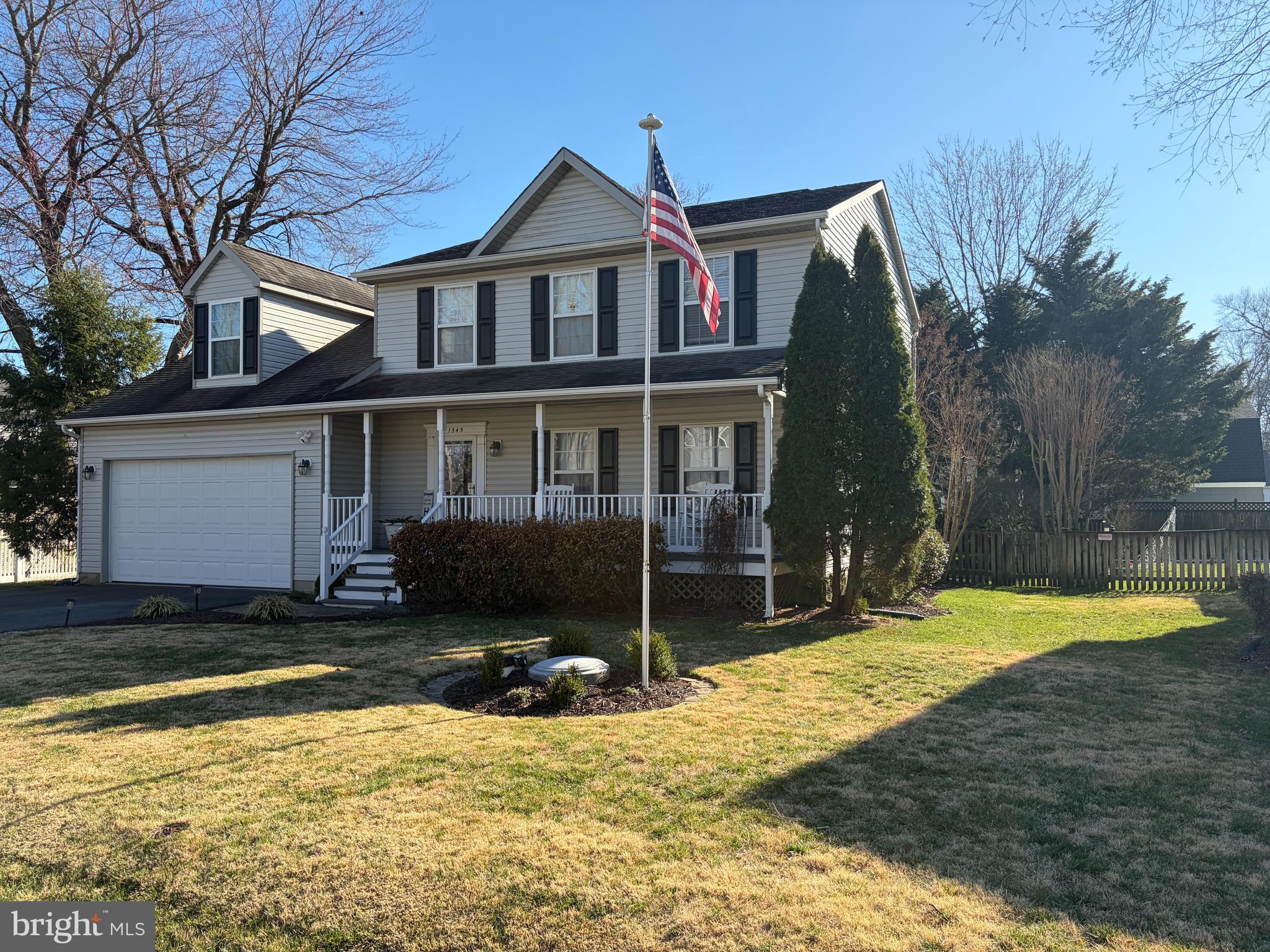 a view of a house with a yard and large tree