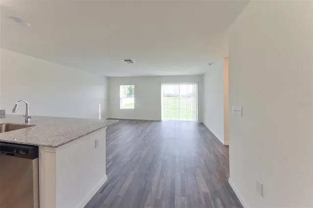 a kitchen with granite countertop stainless steel appliances sink and window