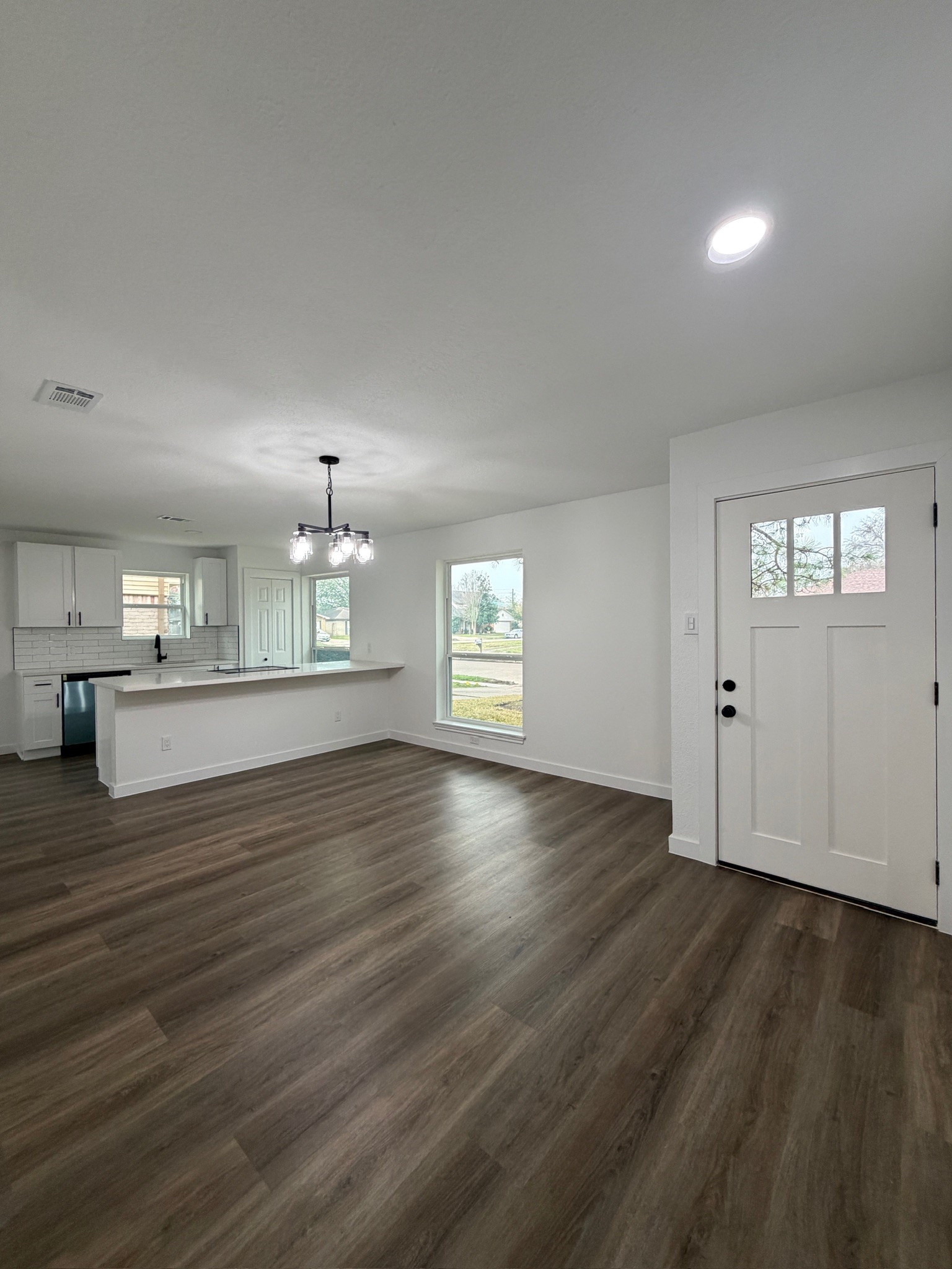 9806 Early Spring Drive Houston, TX 77064 - Photo 3 of 14 an empty room with wooden floor cabinet and windows