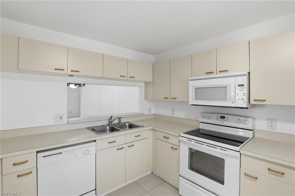 7762 Jewel Lane, Unit 201 Naples, FL 34109 - Photo 11 of 39 a kitchen with appliances cabinets and a sink