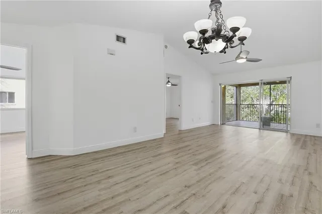 a view of a room with wooden floor and chandelier