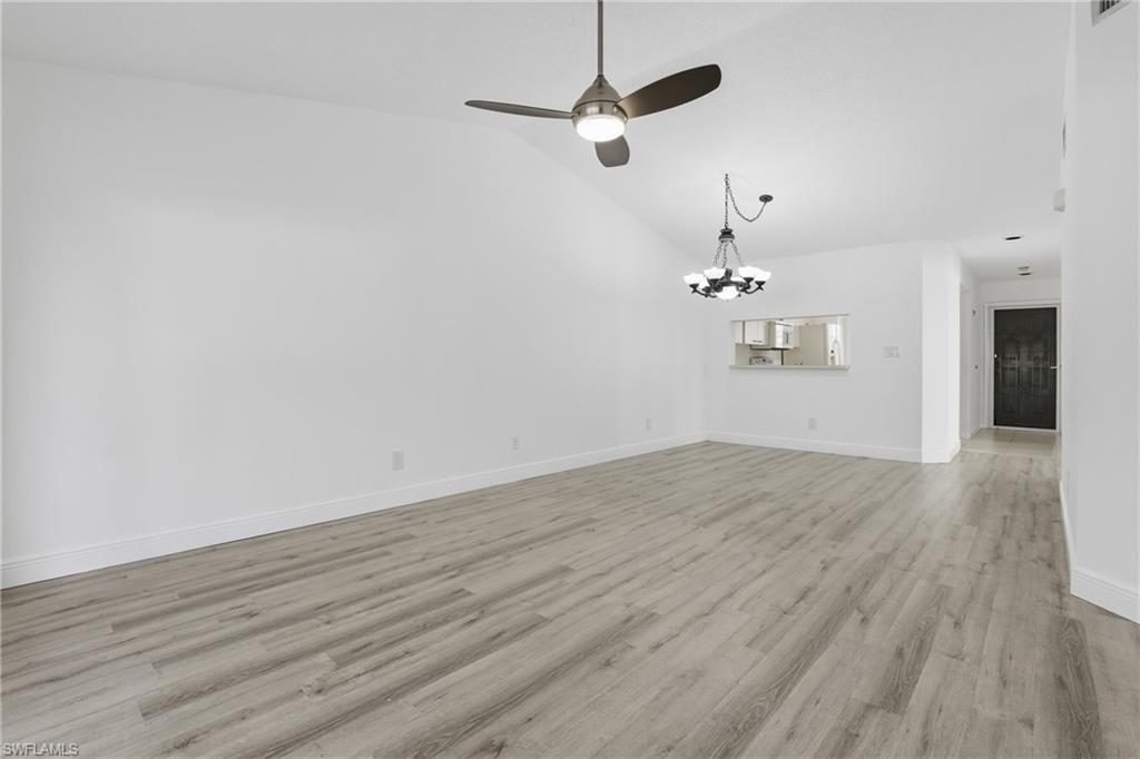 7762 Jewel Lane, Unit 201 Naples, FL 34109 - Photo 14 of 39 an empty room with wooden floor ceiling fan and window