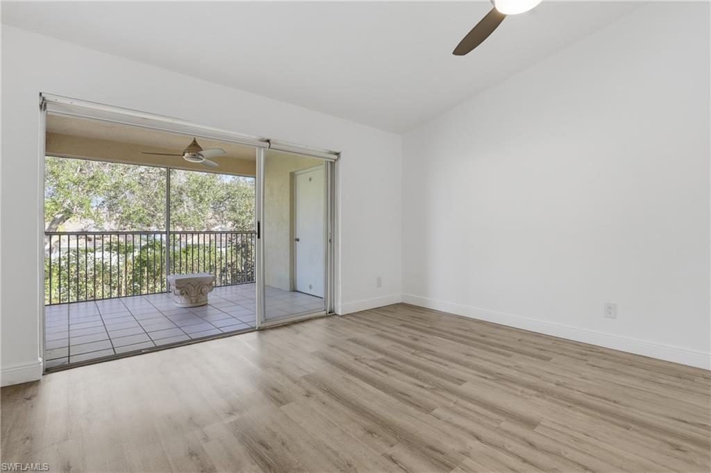 7762 Jewel Lane, Unit 201 Naples, FL 34109 - Photo 16 of 39 an empty room with wooden floor and windows