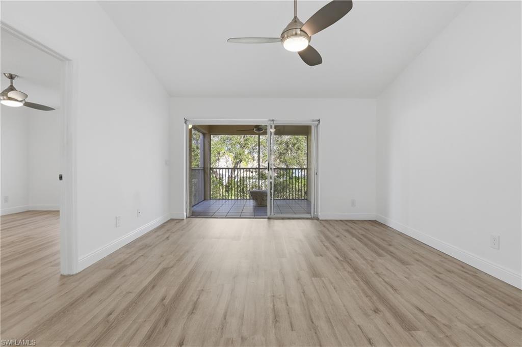 7762 Jewel Lane, Unit 201 Naples, FL 34109 - Photo 17 of 39 an empty room with wooden floor fan and windows