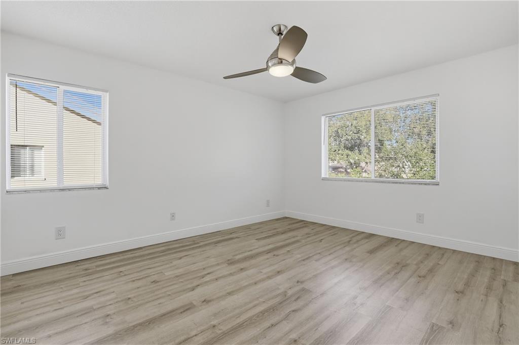 7762 Jewel Lane, Unit 201 Naples, FL 34109 - Photo 18 of 39 a view of an empty room with wooden floor and a window