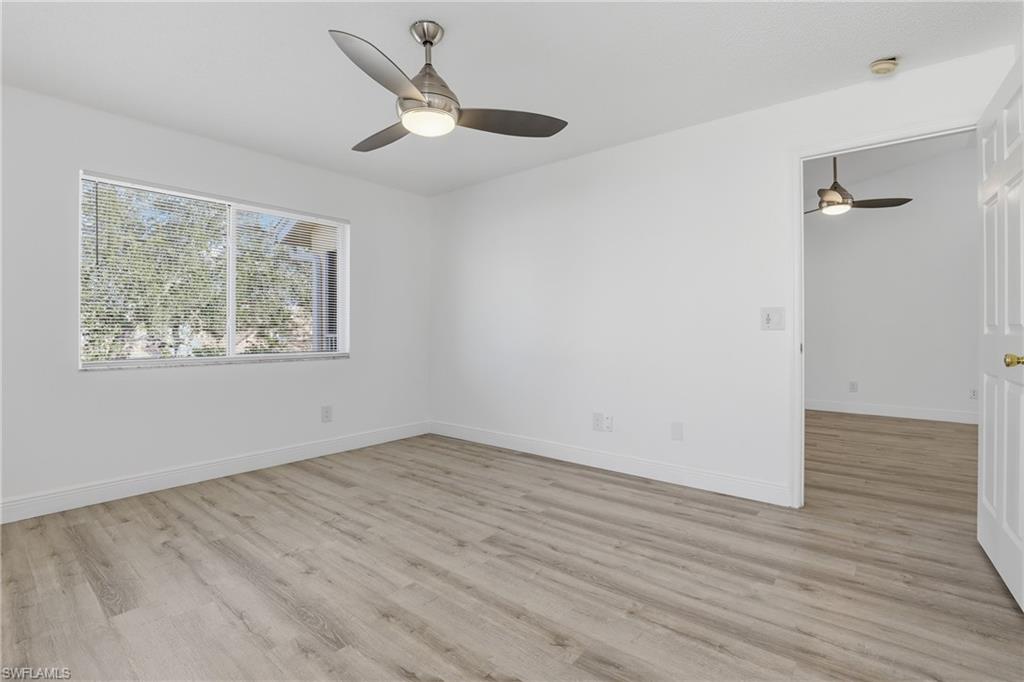 7762 Jewel Lane, Unit 201 Naples, FL 34109 - Photo 20 of 39 wooden floor in an empty room with a window
