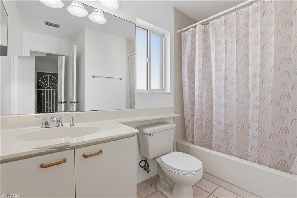 7762 Jewel Lane, Unit 201 Naples, FL 34109 - Photo 27 of 39 a bathroom with a granite countertop sink toilet and a mirror
