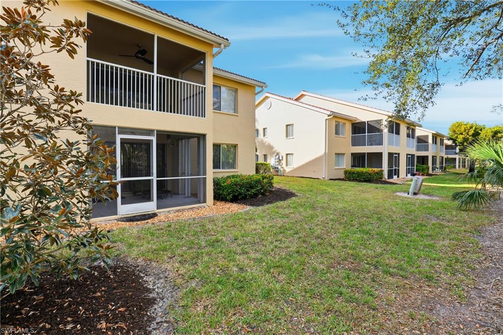 7762 Jewel Lane, Unit 201 Naples, FL 34109 - Photo 33 of 39 a front view of a house with a yard and trees