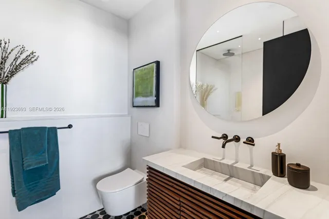 a bathroom with a granite countertop sink a toilet and a mirror