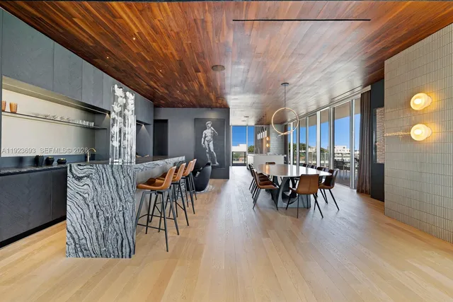 a dining room with furniture a chandelier and wooden floor