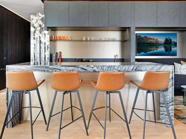 a kitchen with stainless steel appliances kitchen island granite countertop a table and chairs in it