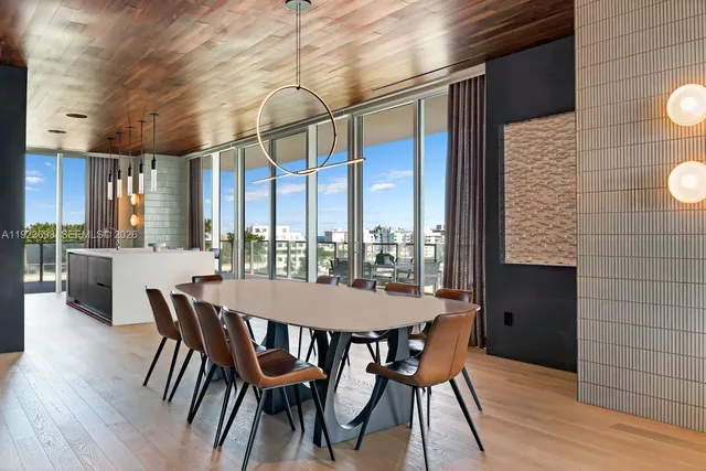 a dining room with furniture a chandelier and wooden floor
