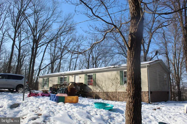 a front view of a house with a yard covered with snow in the background