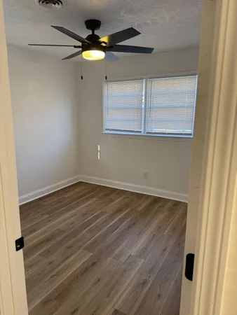 a view of empty room with wooden floor