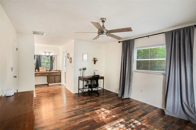 a view of a livingroom with wooden floor and furniture