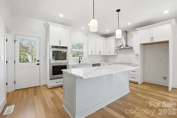 a kitchen with kitchen island a sink stainless steel appliances and cabinets