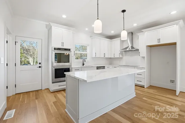 a kitchen with kitchen island a sink stainless steel appliances and cabinets