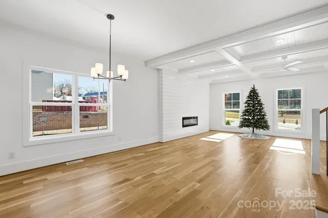 a view of a room with window wooden floor and chandelier