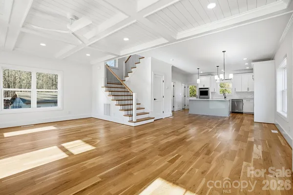 a view of empty room with wooden floor and window