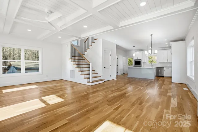 a view of empty room with wooden floor and window