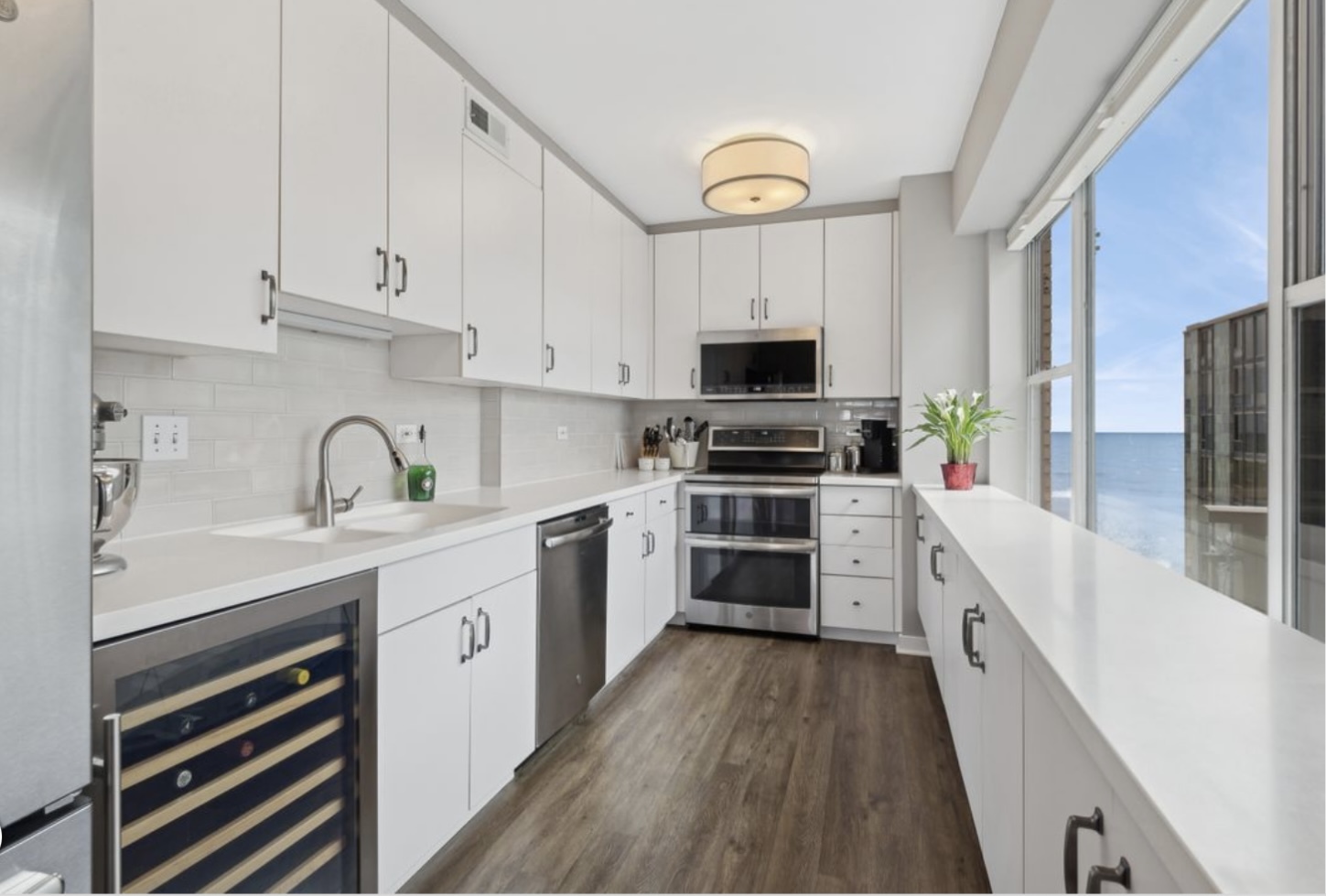 1440 Sheridan Road, Unit 501 Wilmette, IL 60091 - Photo 3 of 20 a kitchen with stainless steel appliances a sink dishwasher a refrigerator and a stove with wooden floor