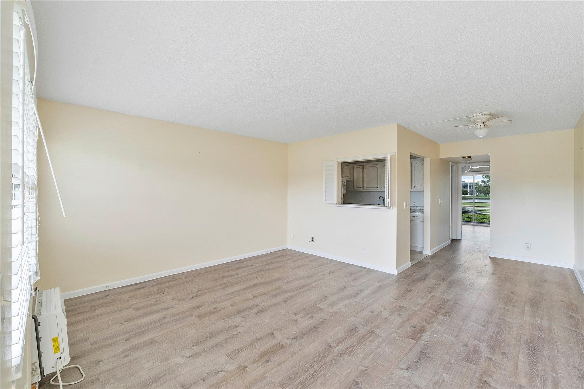 358 Dorset I, Unit 358 Boca Raton, FL 33434 - Photo 6 of 12 an empty room with wooden floor and windows