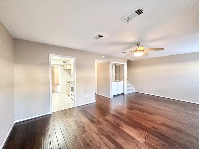 a view of an empty room with wooden floor