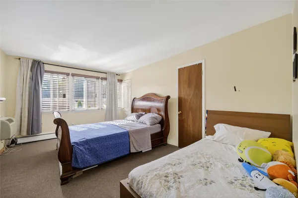 a bedroom with two beds and large window