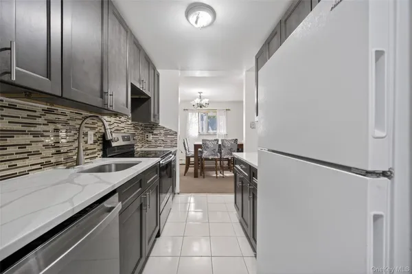 a kitchen with granite countertop a sink stove and refrigerator