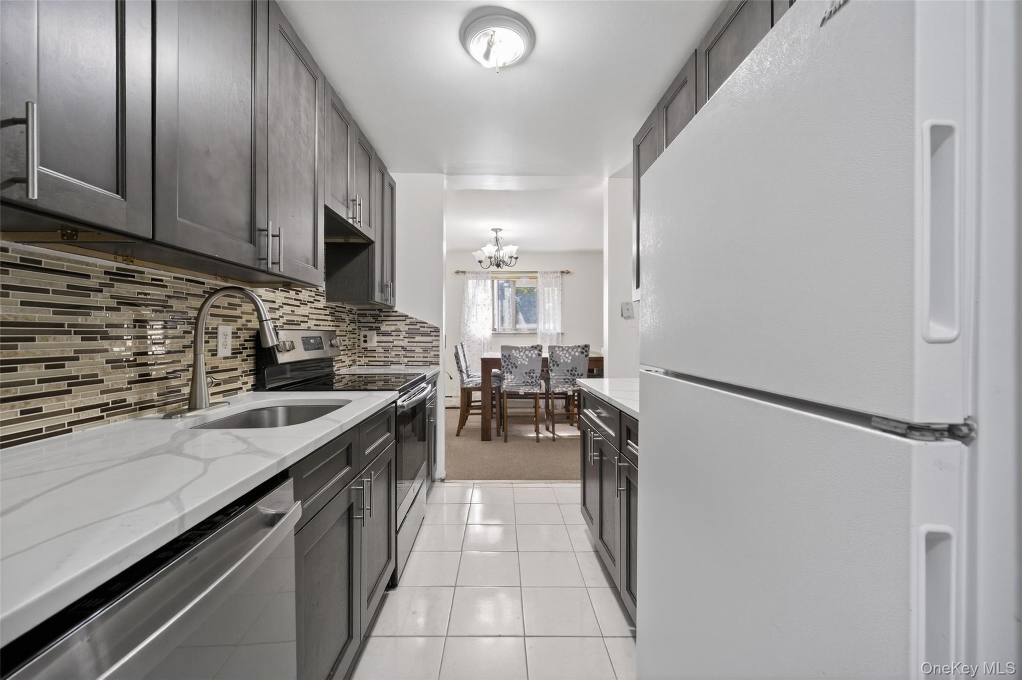 4 Secora, Unit E2 Monsey, NY 10952 - Photo 4 of 24 a kitchen with granite countertop a sink stove and refrigerator