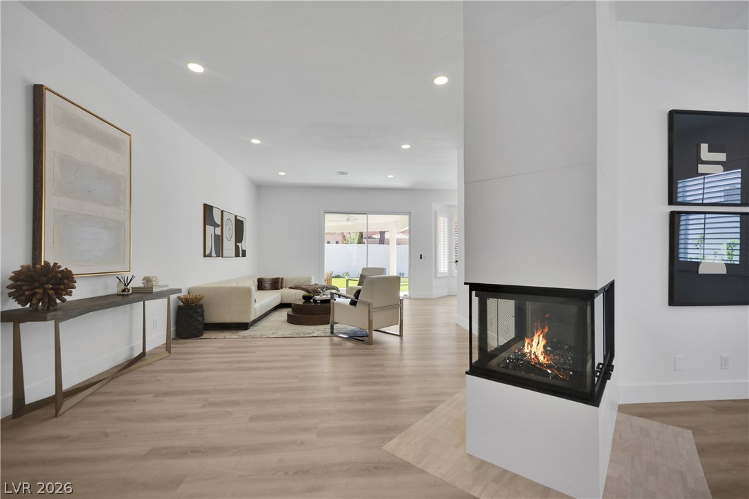 8981 Rivers Edge Drive Las Vegas, NV 89117 - Photo 14 of 69 A corner fireplace adds warmth and ambiance to this generous living space with direct outdoor access.