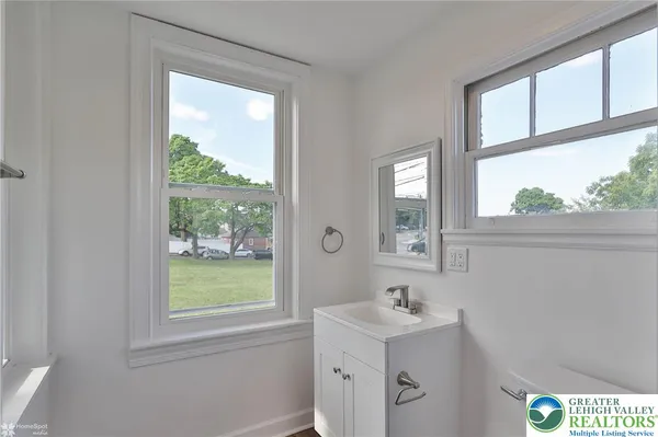 a bathroom with a sink a mirror and a window