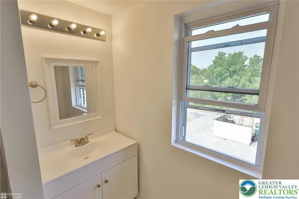 a bathroom with a sink a mirror and a window