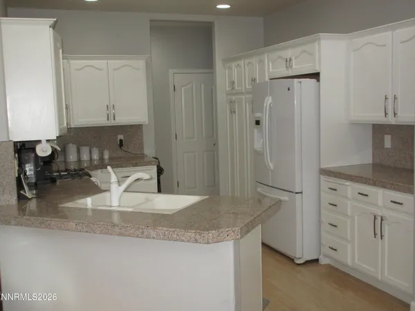 a kitchen with white cabinets and refrigerator