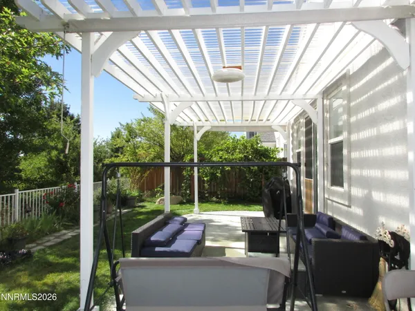 a view of a backyard with couches plants and large tree