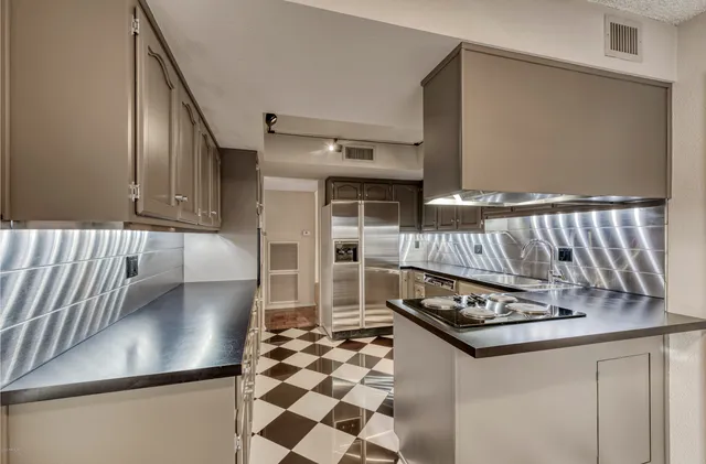 a kitchen with stainless steel appliances granite countertop a stove a sink and a refrigerator